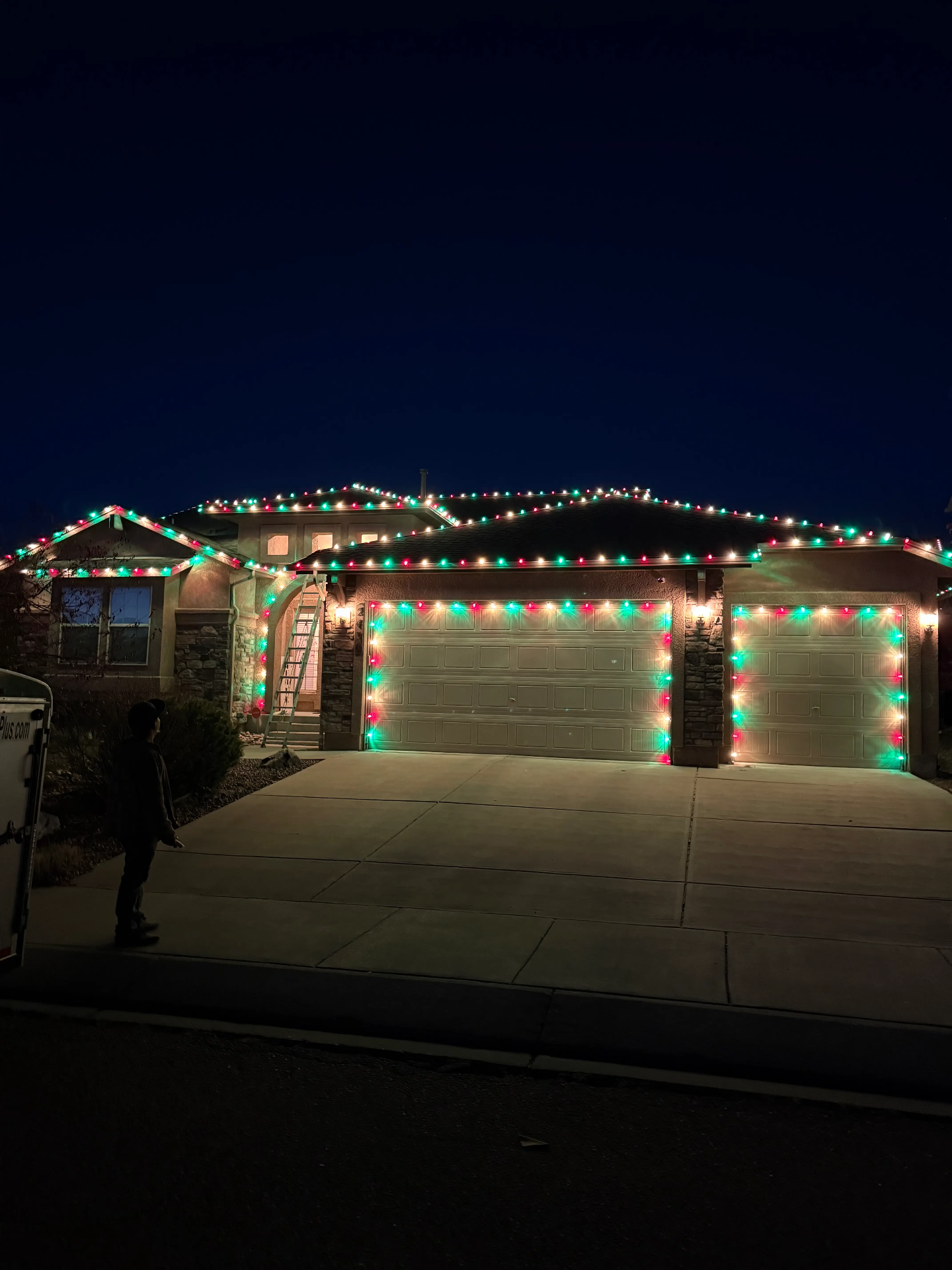 Portfolio example: red and green LED roofline and garage Christmas lights on a Front Range home