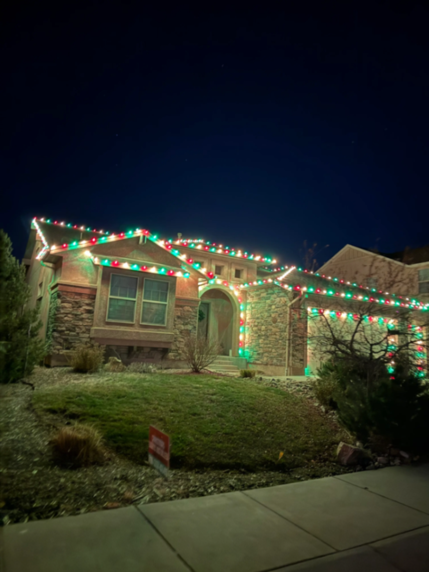 Portfolio example: multicolor LED Christmas lights with roofline and landscape lighting on a two-story home