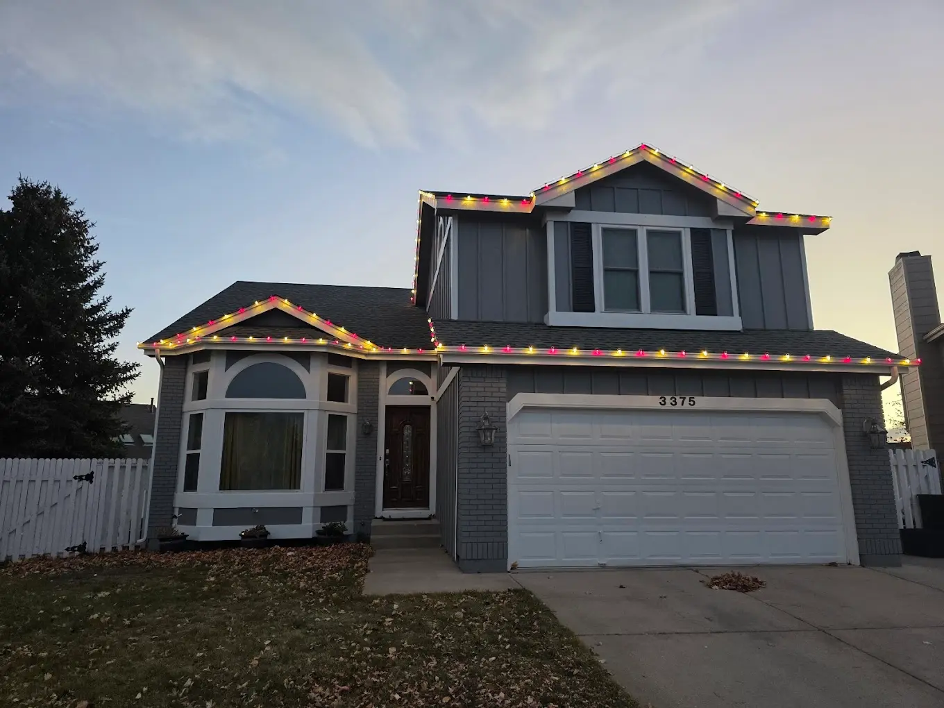 Portfolio example: multicolor C9 Christmas lights along the roof peaks of a two-story home